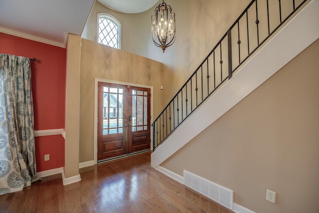 entrance foyer featuring visible vents, hardwood / wood-style flooring, a high ceiling, stairs, and french doors