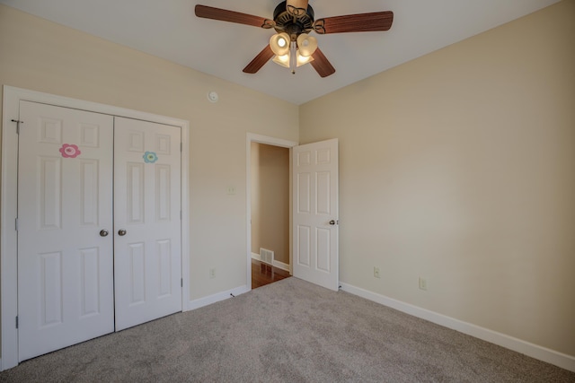 unfurnished bedroom with a closet, carpet flooring, visible vents, and baseboards