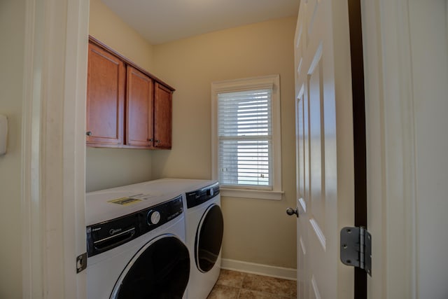 laundry room featuring cabinet space, baseboards, and washer and clothes dryer