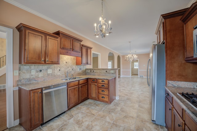 kitchen featuring brown cabinetry, a peninsula, a sink, stainless steel appliances, and a notable chandelier