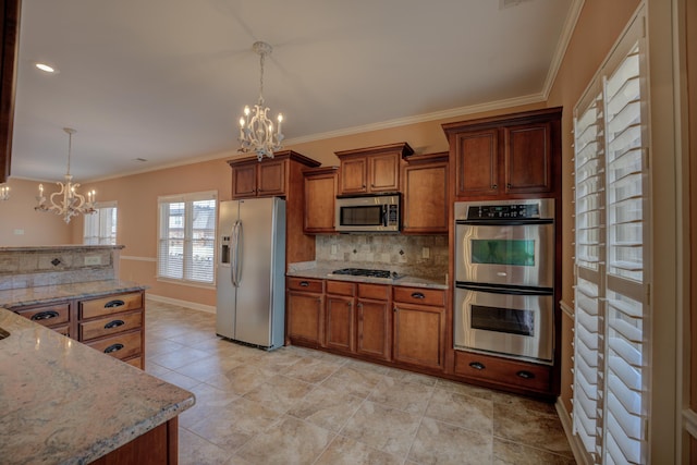 kitchen featuring brown cabinets, decorative backsplash, stainless steel appliances, and a notable chandelier