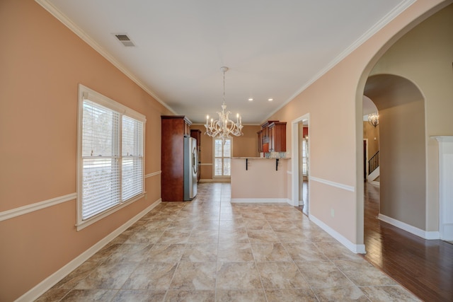 interior space featuring baseboards, visible vents, a chandelier, and ornamental molding