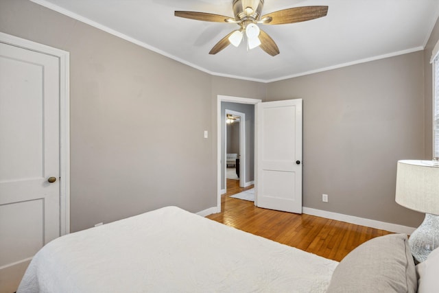 bedroom featuring baseboards, ceiling fan, wood finished floors, and crown molding