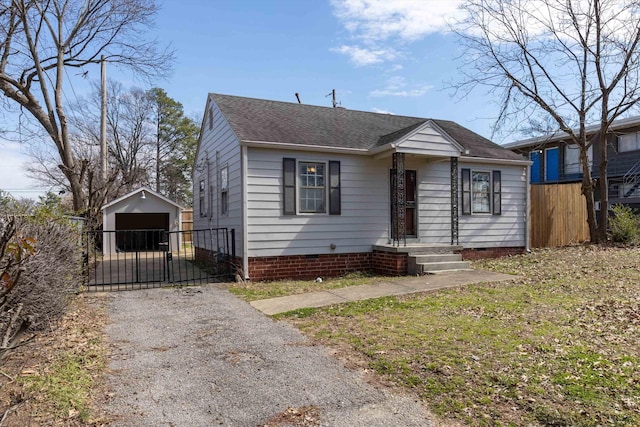 bungalow-style house with crawl space, roof with shingles, fence, and an outdoor structure