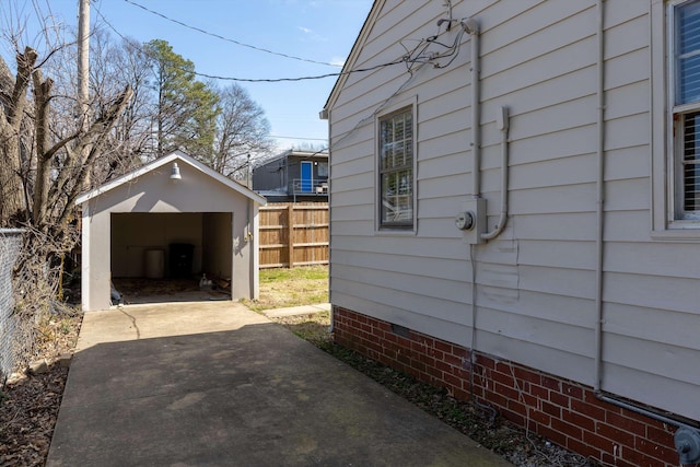 view of home's exterior featuring an outdoor structure, a shed, fence, driveway, and a garage