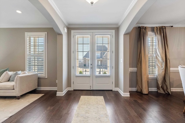 entrance foyer with arched walkways, dark wood finished floors, and crown molding