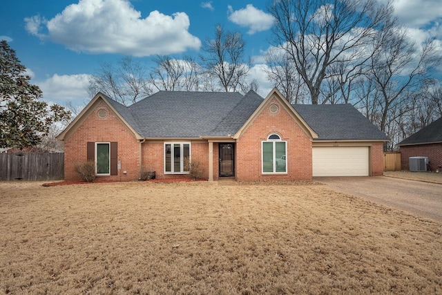 ranch-style house featuring brick siding, fence, driveway, and an attached garage