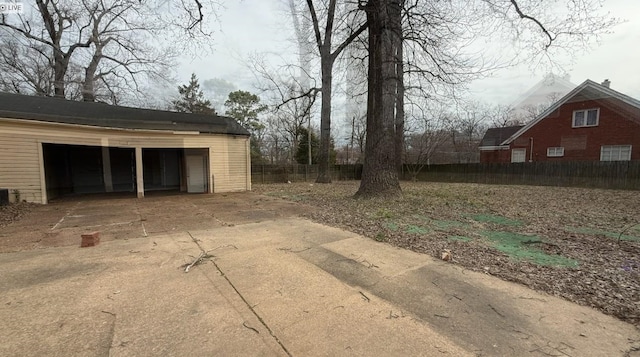 view of yard featuring a garage, fence, and an outdoor structure