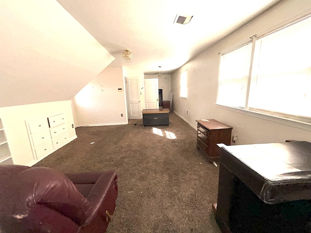 living area with lofted ceiling, visible vents, dark carpet, and baseboards