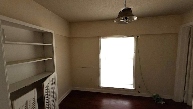 empty room featuring dark wood finished floors and baseboards