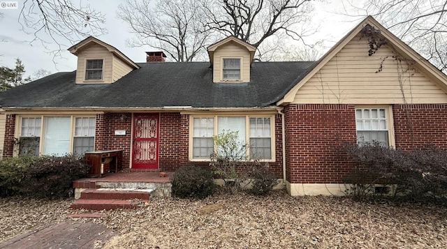 view of front of house with brick siding and a chimney