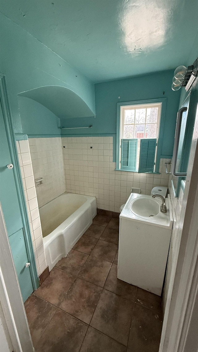 bathroom featuring tile patterned flooring, vanity, and tile walls