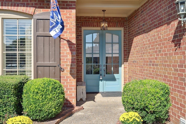 doorway to property featuring french doors and brick siding