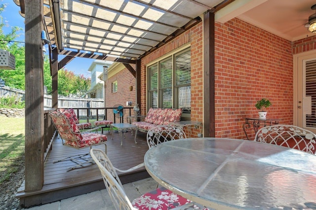 wooden terrace featuring outdoor dining area, fence, a ceiling fan, and a pergola