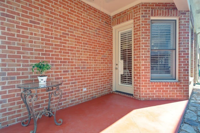 entrance to property with a patio area and brick siding