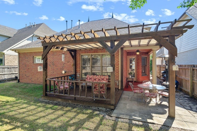 rear view of house with a yard, brick siding, fence, and a pergola