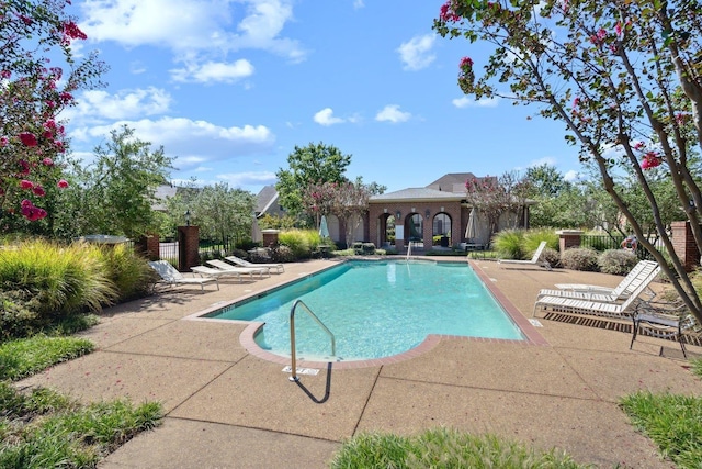 community pool with fence and a patio