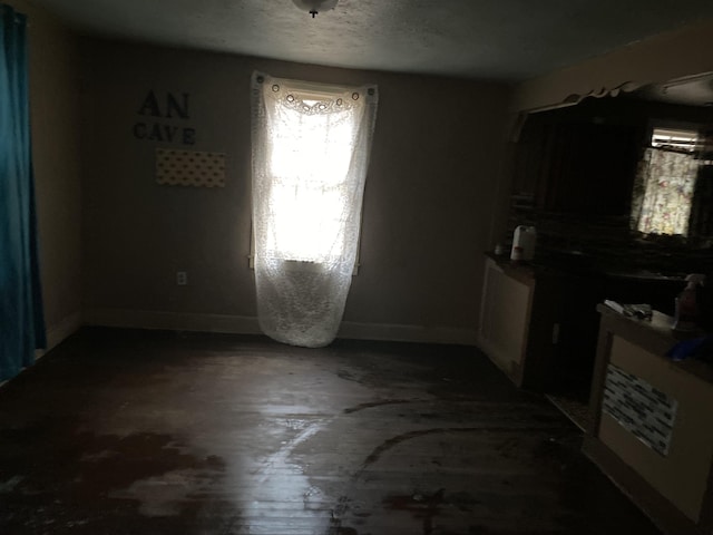 dining room with baseboards and a textured ceiling