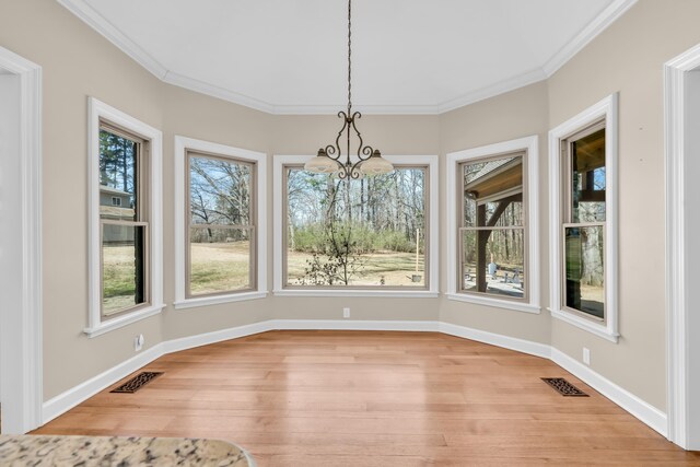 unfurnished dining area featuring visible vents, crown molding, and light wood-style flooring