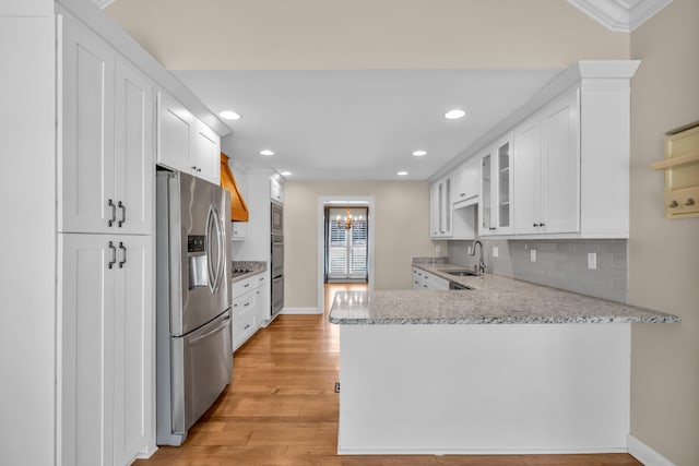 kitchen featuring appliances with stainless steel finishes, a sink, and white cabinetry