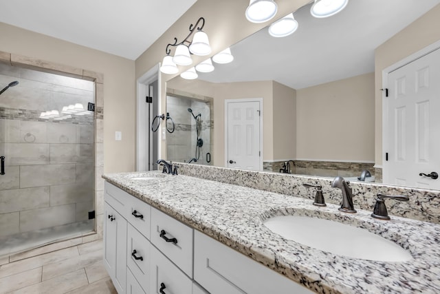 full bath featuring double vanity, a stall shower, and a sink