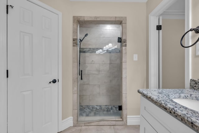 full bath featuring a shower stall, vanity, and baseboards