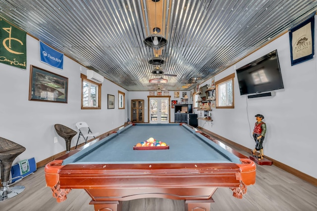 game room with baseboards, wood finished floors, an AC wall unit, and french doors