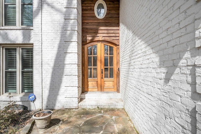 property entrance with french doors and brick siding