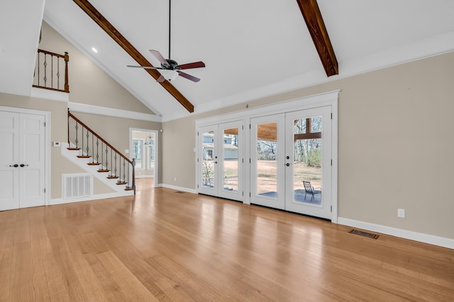 unfurnished living room featuring stairway, visible vents, beam ceiling, and french doors