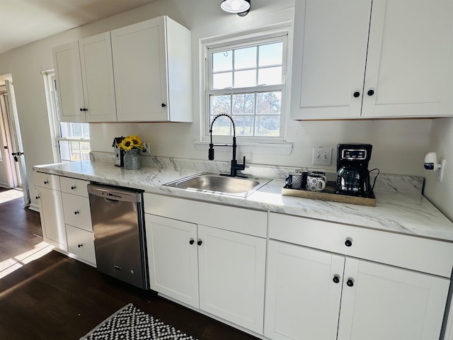 kitchen with dark wood-type flooring, white cabinetry, a sink, and stainless steel dishwasher