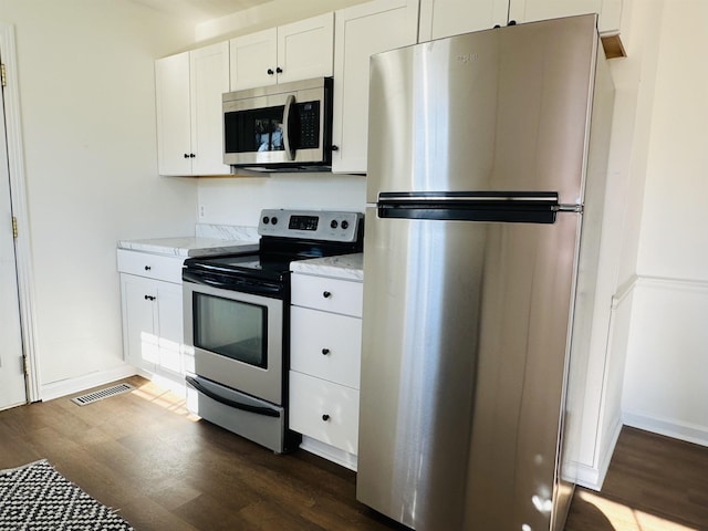 kitchen featuring stainless steel appliances, dark wood-type flooring, and white cabinetry