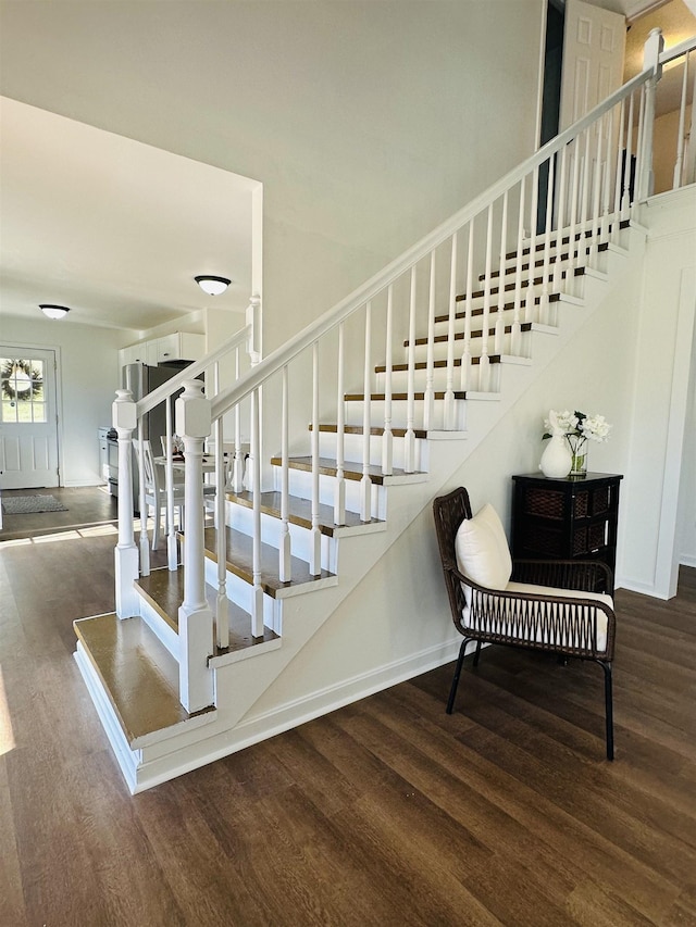 stairs featuring wood finished floors and baseboards