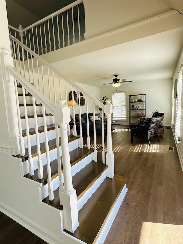 stairs featuring visible vents, wood finished floors, a ceiling fan, and baseboards