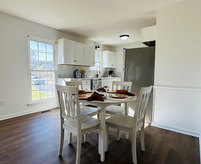 dining space with baseboards, visible vents, and dark wood-style flooring