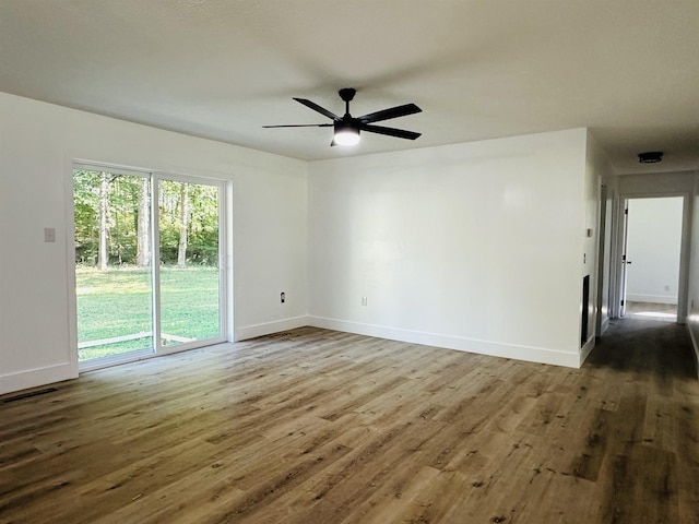 spare room featuring a ceiling fan, baseboards, and wood finished floors