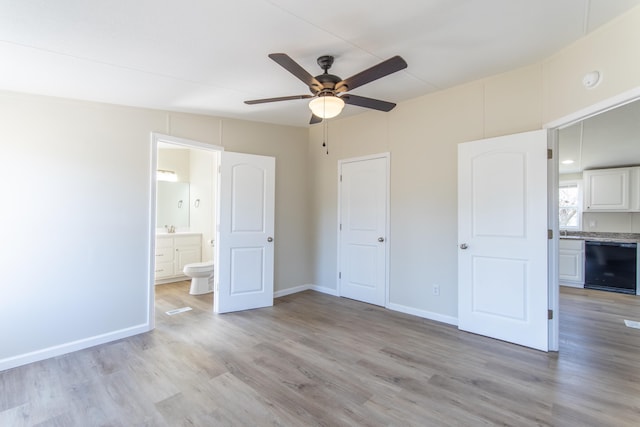 unfurnished bedroom with connected bathroom, light wood-style flooring, a sink, a ceiling fan, and baseboards