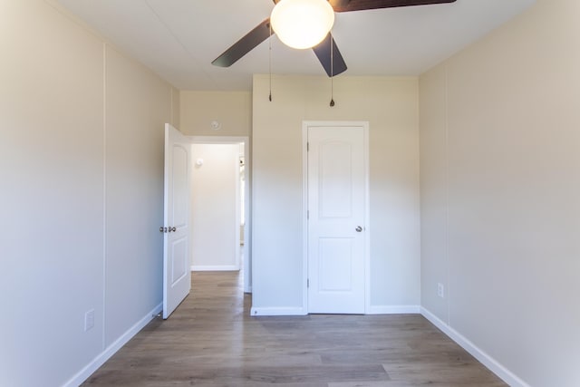 unfurnished bedroom with a ceiling fan, baseboards, and wood finished floors