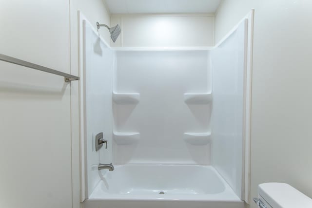 bathroom with toilet and tub / shower combination