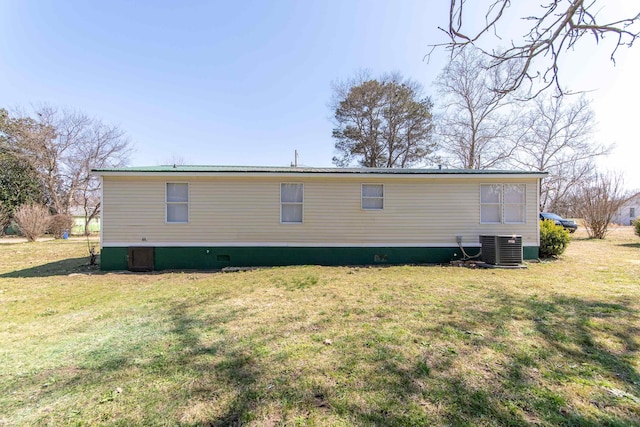 rear view of house featuring metal roof, central AC, a yard, and crawl space