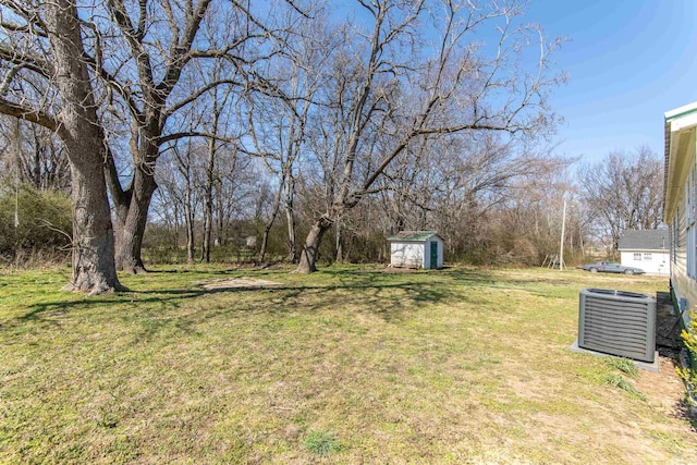 view of yard with a storage shed, central AC unit, and an outbuilding