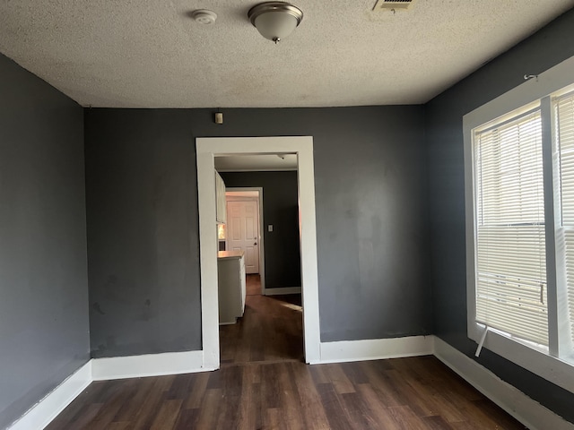 empty room featuring plenty of natural light, baseboards, and wood finished floors