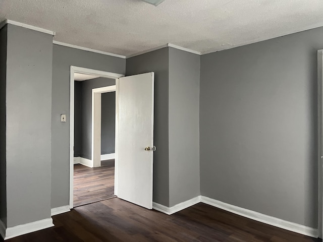 empty room with baseboards, wood finished floors, and ornamental molding