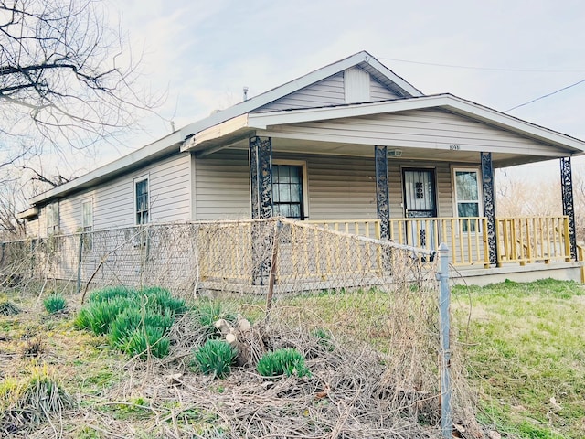 view of front of property featuring fence and covered porch