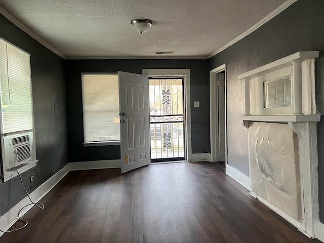 entryway with ornamental molding, visible vents, a textured ceiling, and wood finished floors