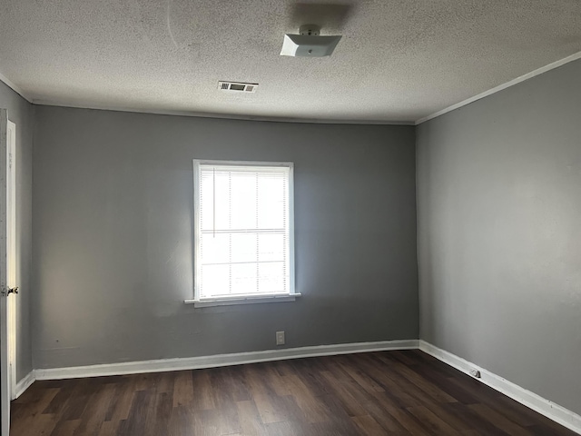 empty room featuring dark wood finished floors, visible vents, and baseboards