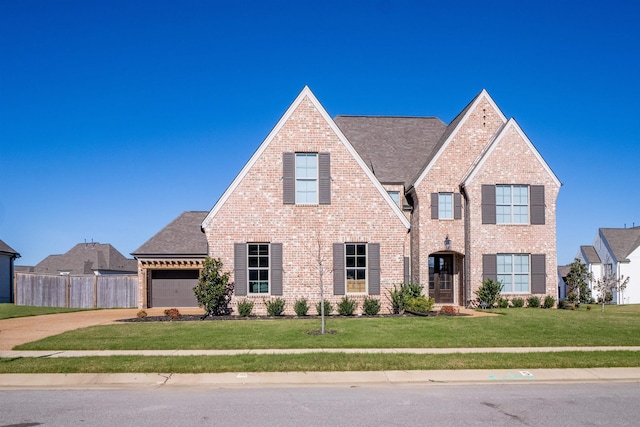 view of front facade featuring driveway, an attached garage, fence, a front lawn, and brick siding