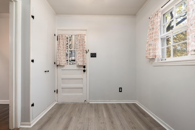 entryway featuring crown molding, baseboards, and wood finished floors