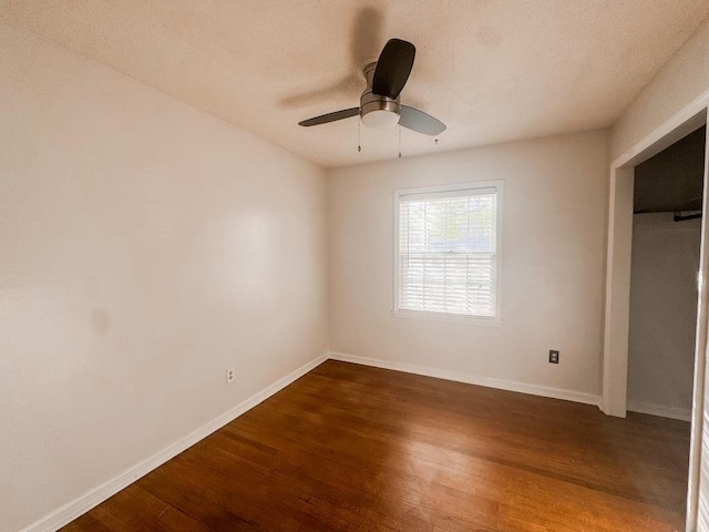 unfurnished bedroom with ceiling fan, wood finished floors, and baseboards