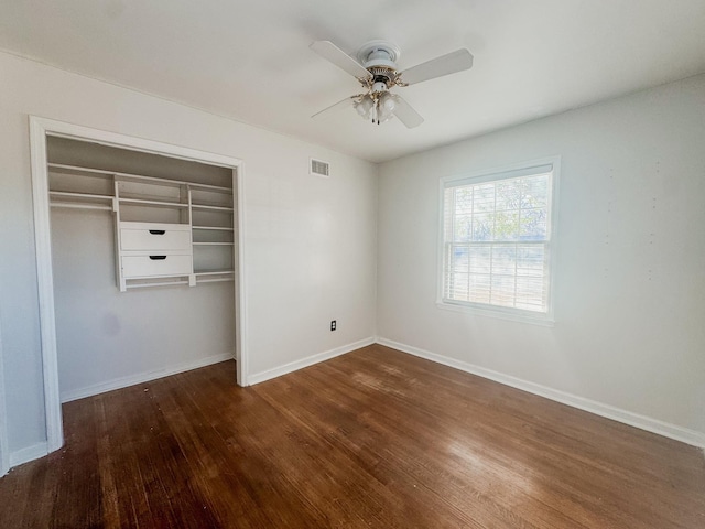 unfurnished bedroom featuring visible vents, baseboards, a ceiling fan, wood finished floors, and a closet