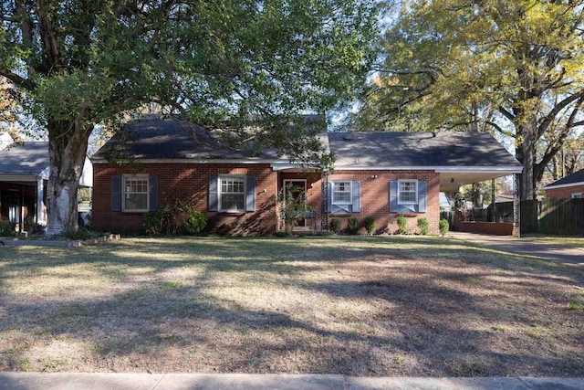 single story home with a carport, brick siding, a front yard, and fence